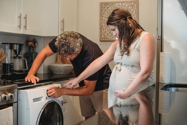 couple operates their washing machine